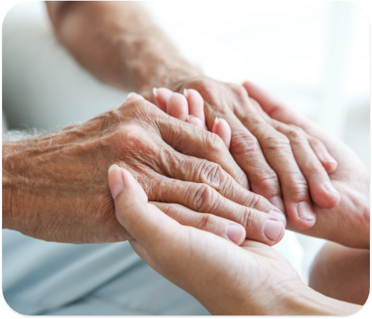 An elderly person holding hands with a younger person