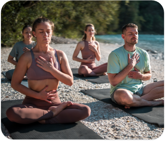 A group of people doing meditation on the beach