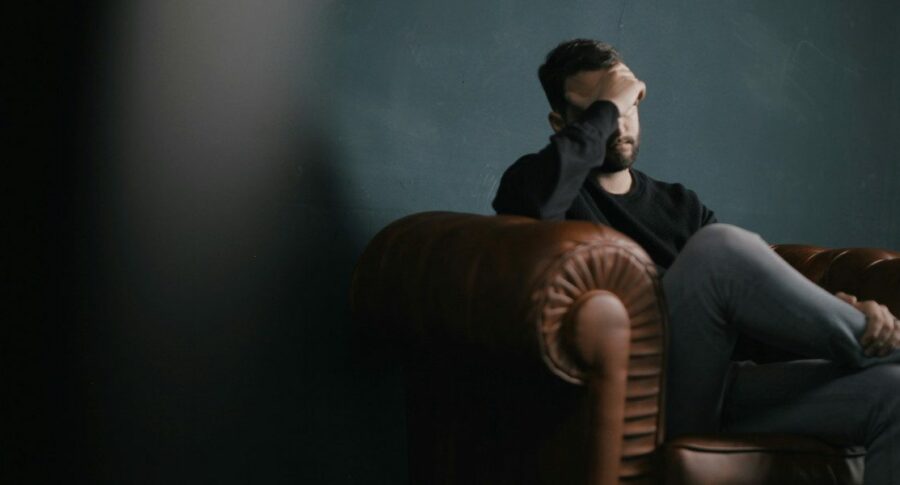 man sitting in the dark in a chair